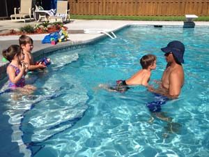 A family swimming in the pool together.