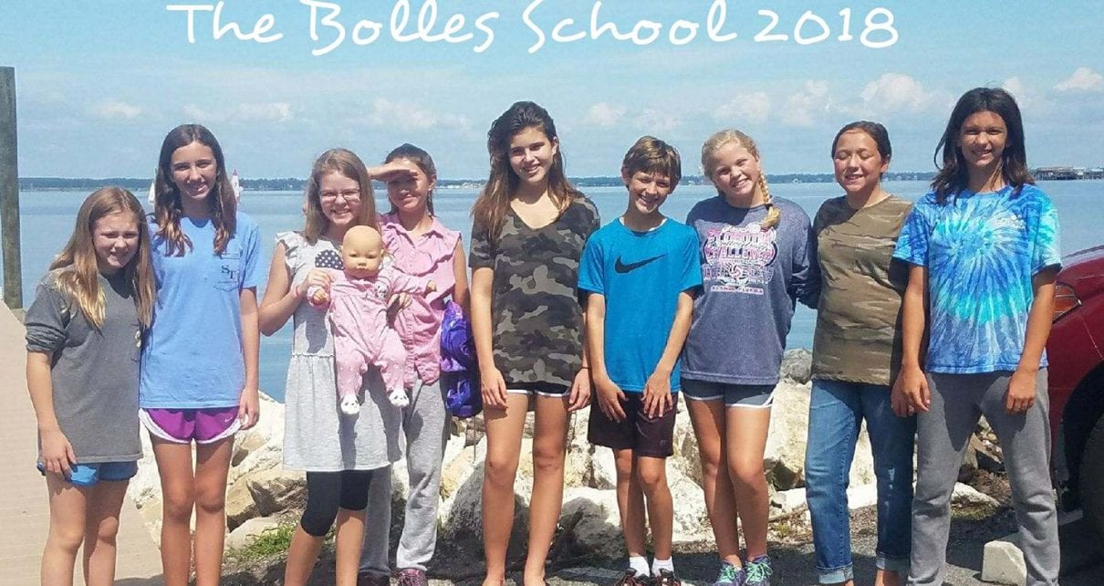 A group of people standing on top of a beach.