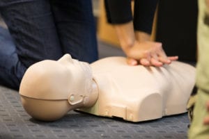 photo of CPR dummy with person pushing on chest