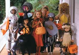 Children in Halloween costumes holding candy bags.