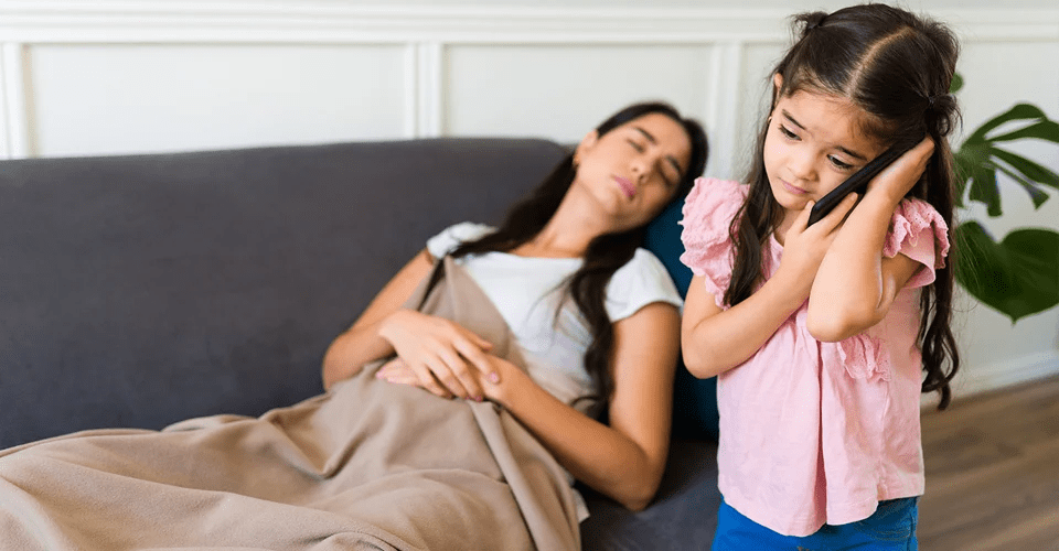 A woman and girl are sleeping on the couch.